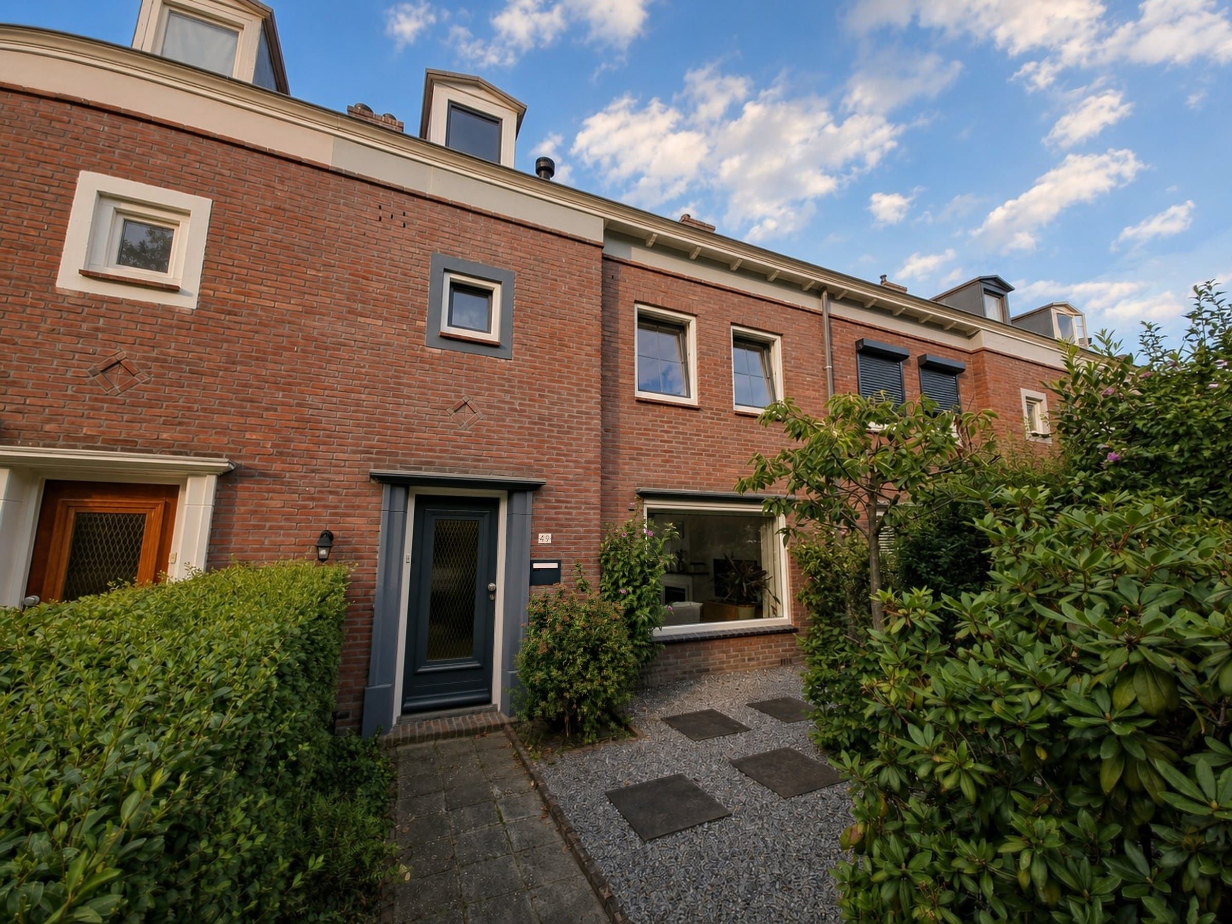 Brede voorgevel en groene voortuin