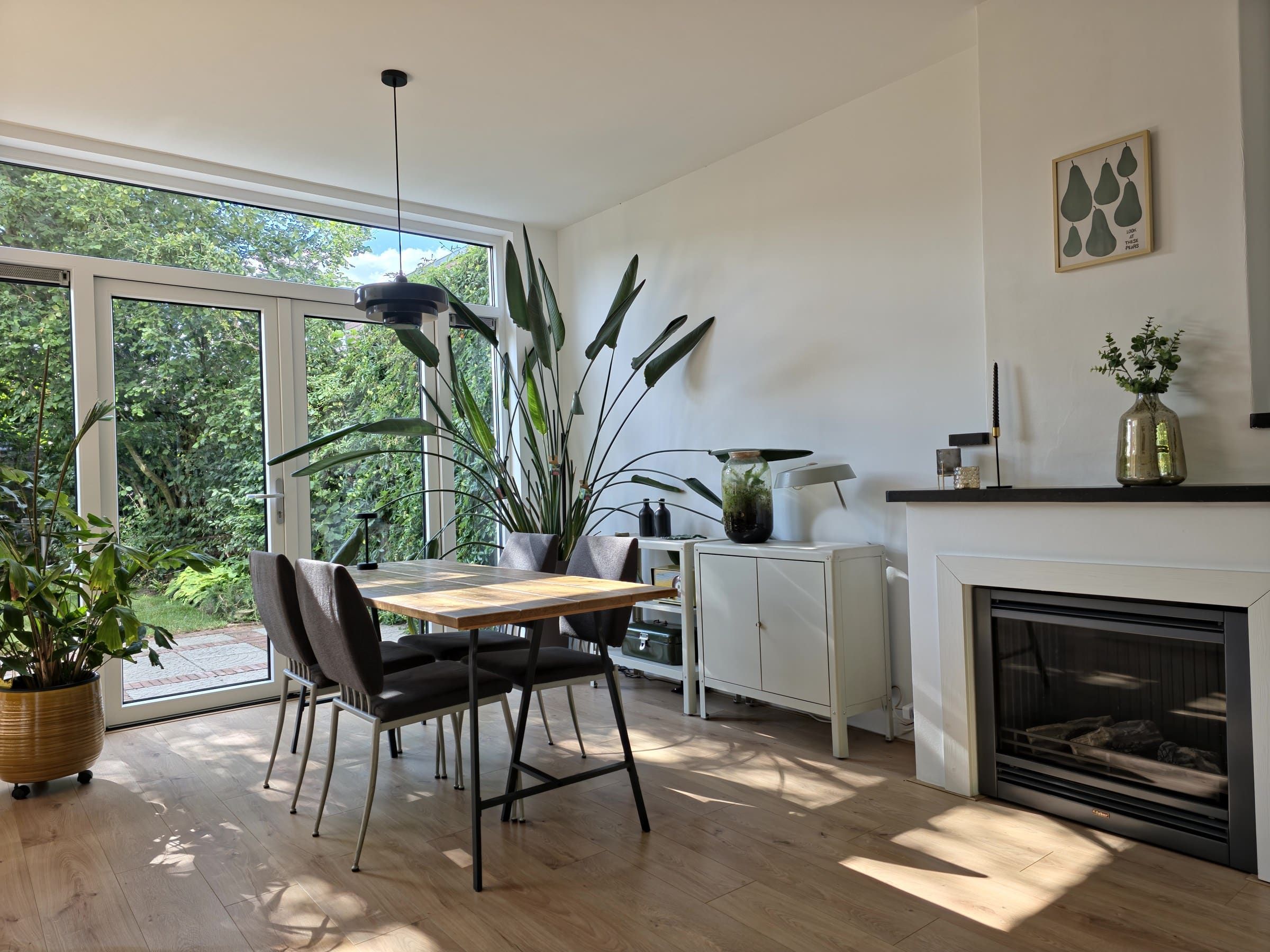 Lichte eethoek met haard en uitzicht op de tuin