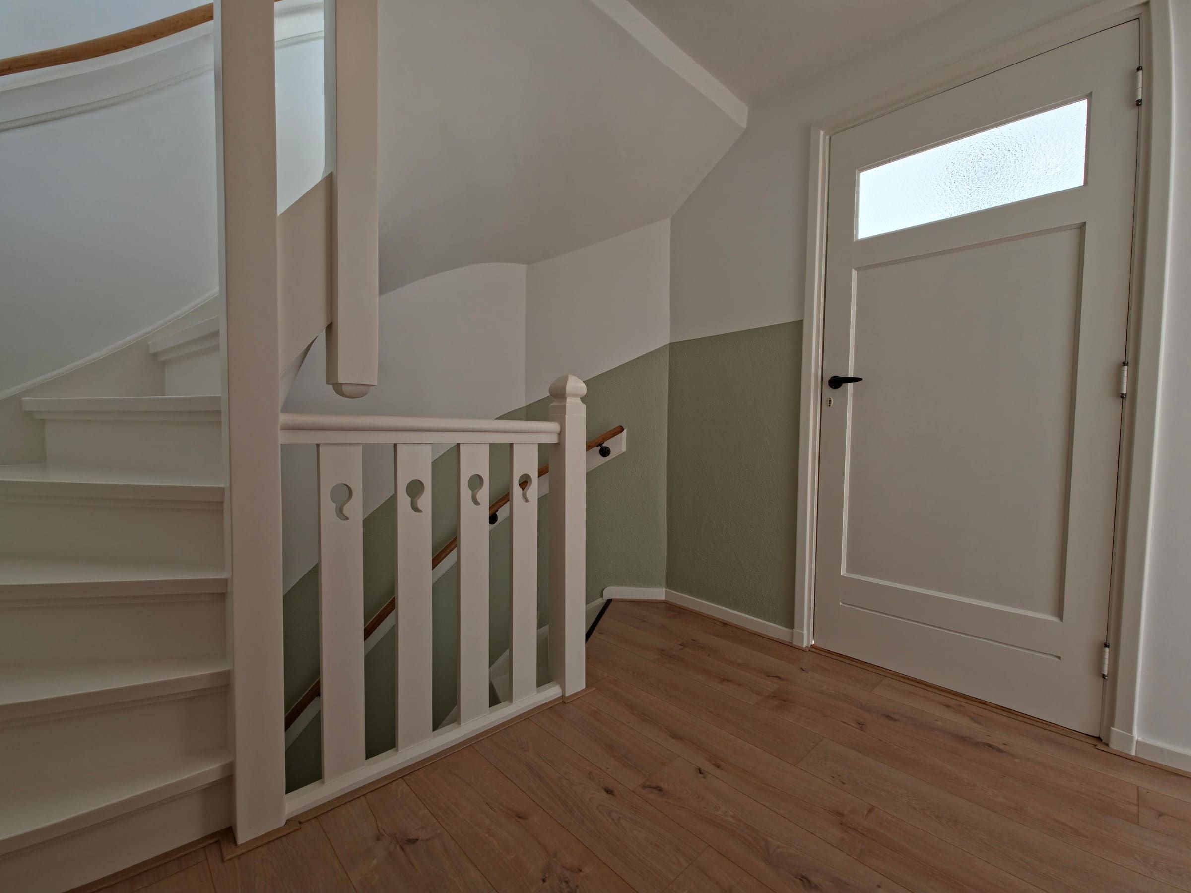 Lichte overloop bij de trap met origineel houten detail