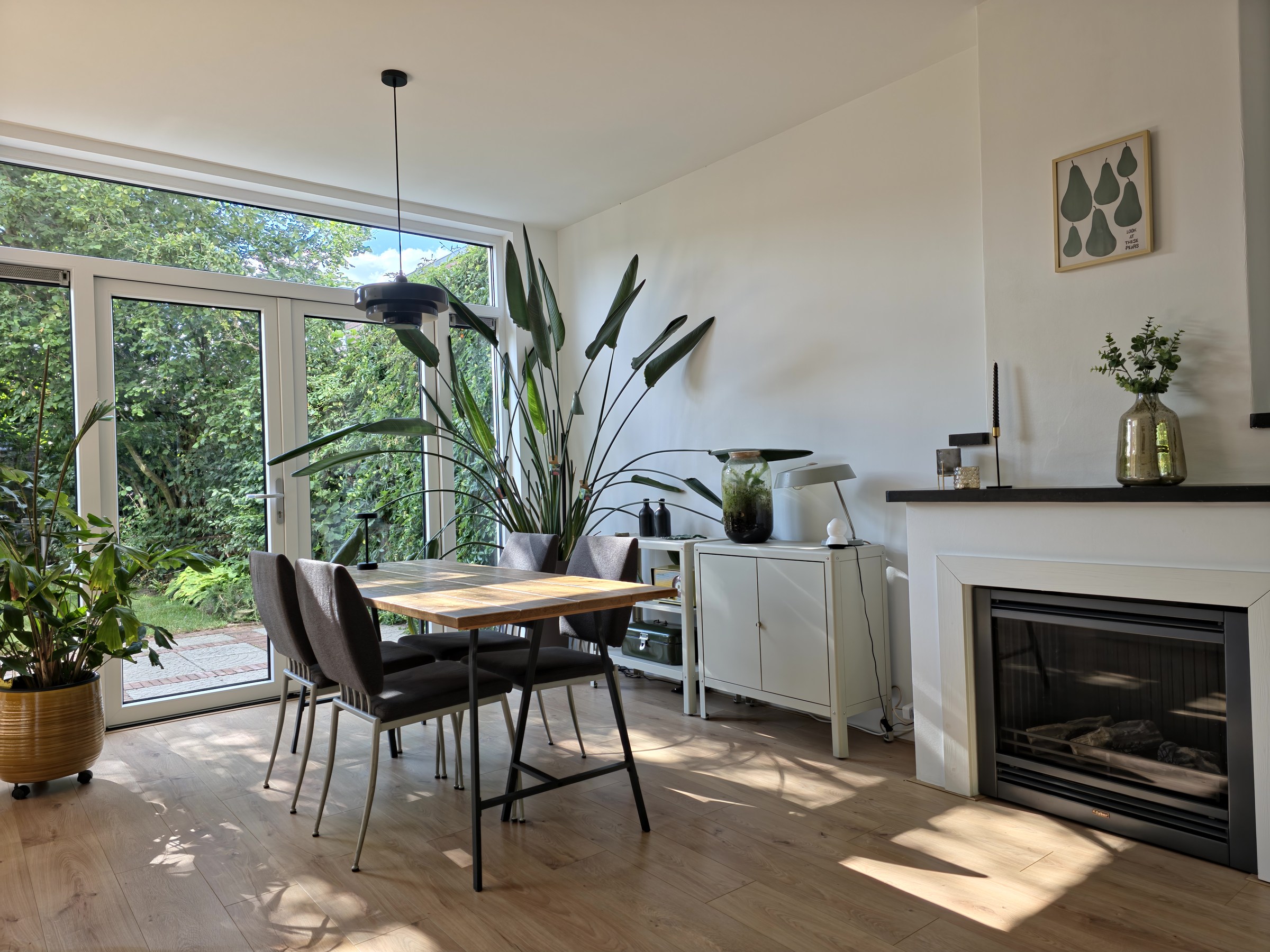 Lichte eethoek met haard en uitzicht op de tuin