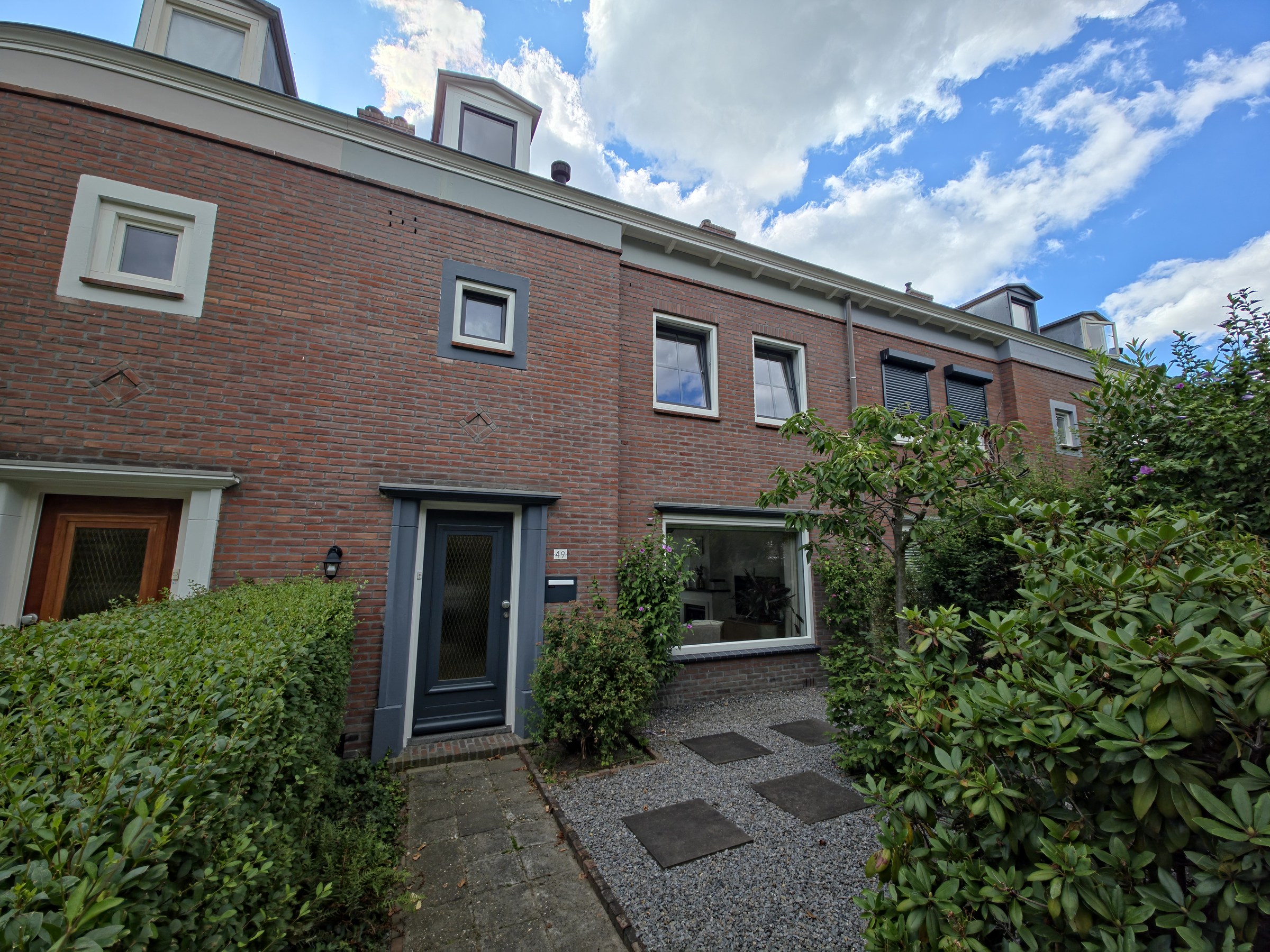 Voorgevel en groene voortuin in een uitnodigende compositie